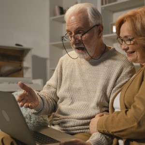 A couple at home watching an event on a laptop