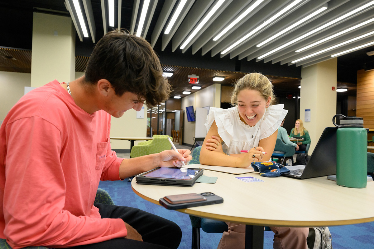 A peer tutor working with a student in the Harte Center
