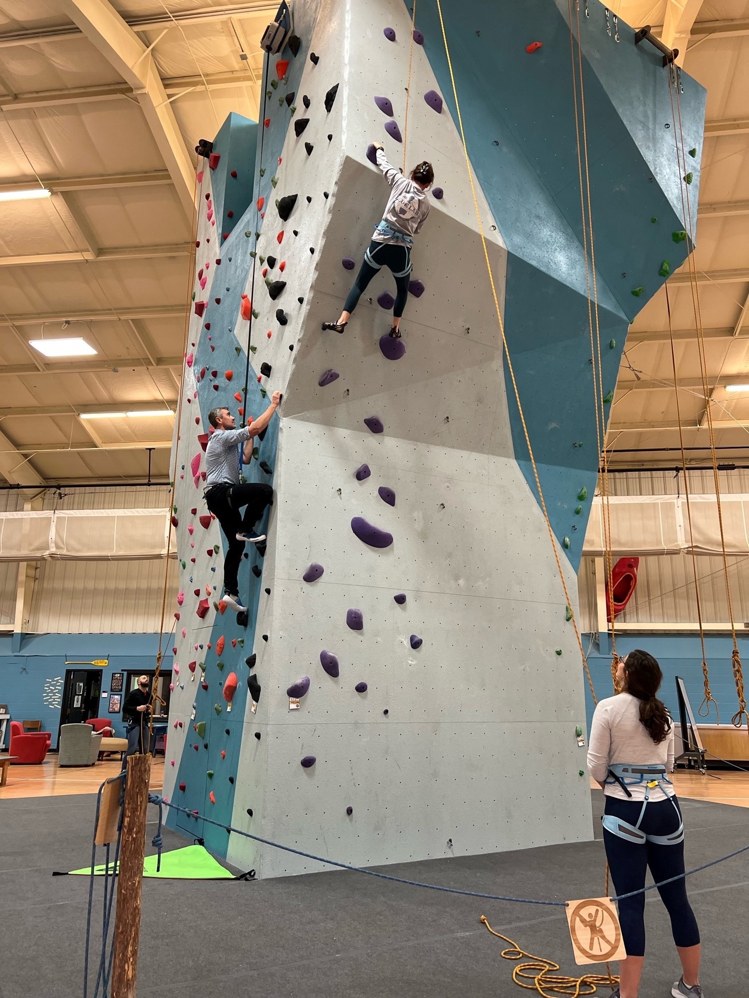 Photo of individuals on the climbing wall