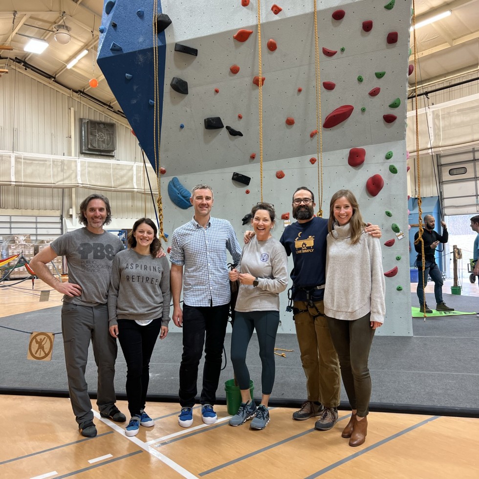 Photo of individuals on the climbing wall