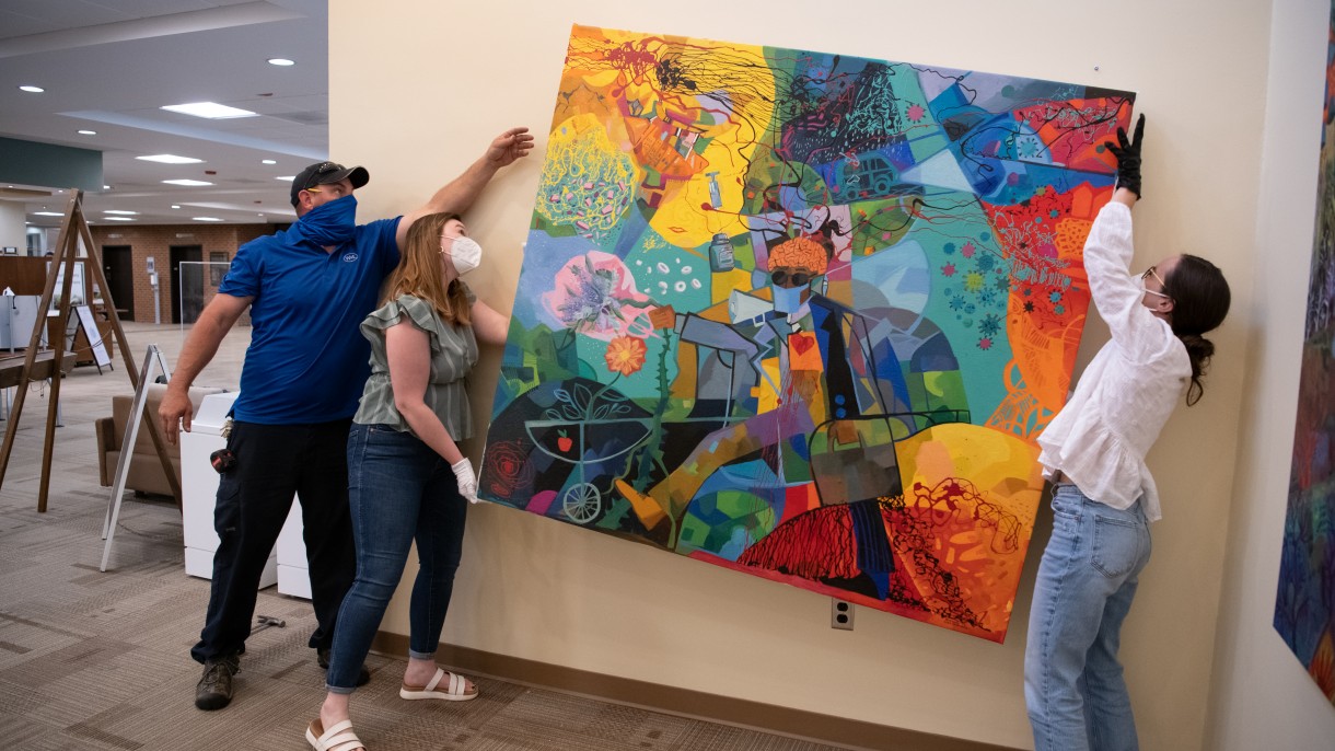 Students setting up paintings for the Chaos in Color exhibit