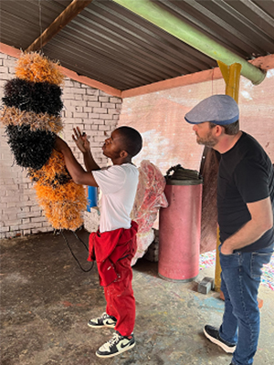 Professor Sandy de Lissovoy pictured with artist Tafadzwa Chataika at Mbare Art Space in 2025