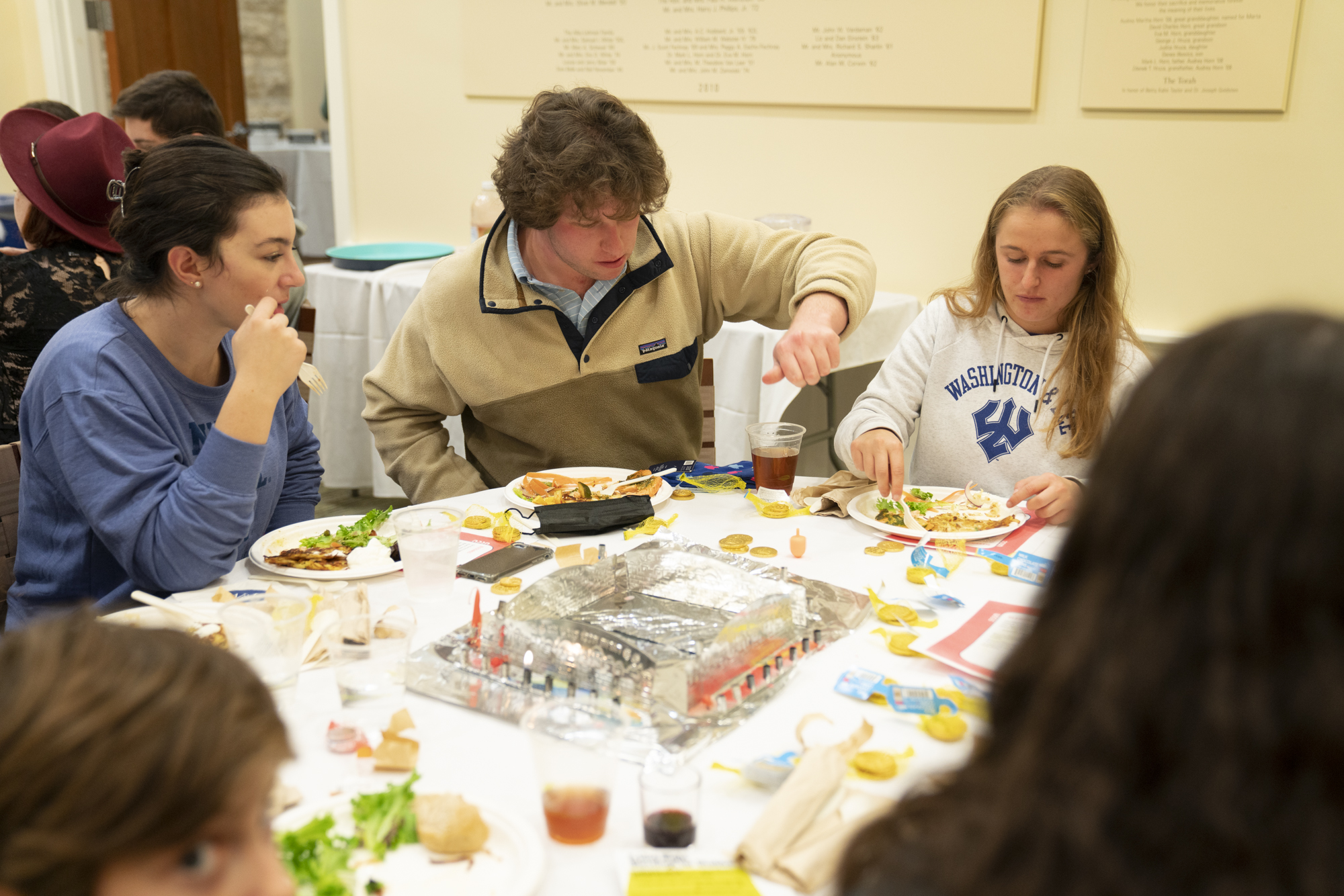 Students play dreidel at Hanukkah Shabbat