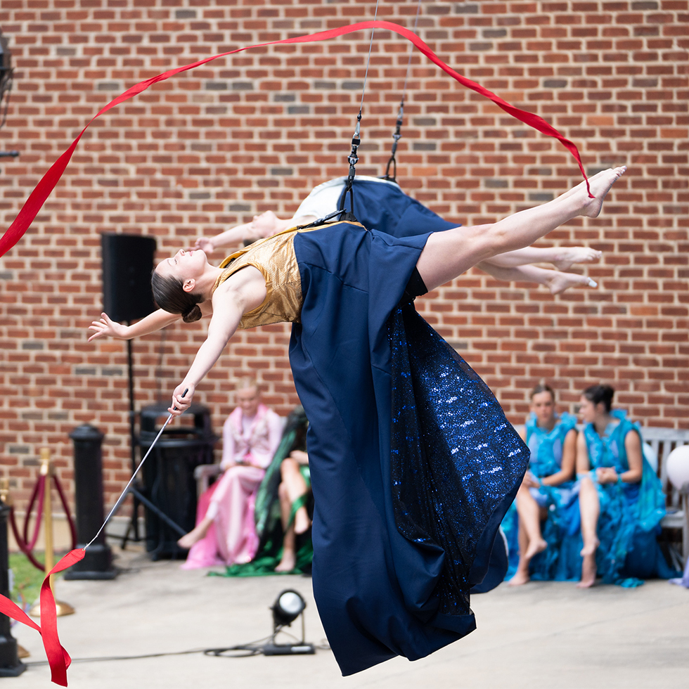 Students in an Aerial Dance class perform in "Vertical Dance" on the wall outside Wilson Hall