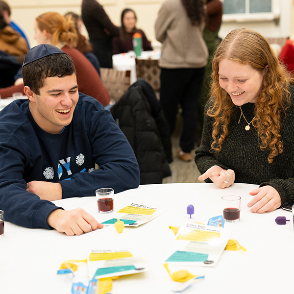 Students spin dreidels during the Hanukkah Shabbat in the Hillel House