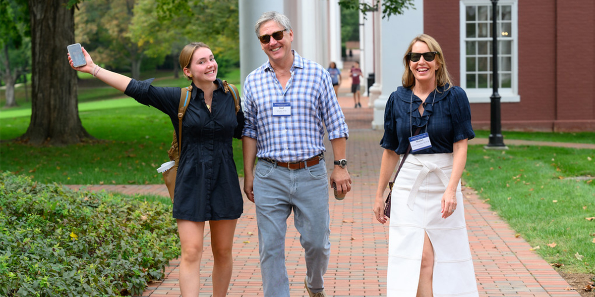 Student walking with parents on campus